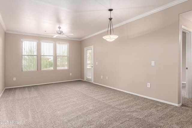 spare room with crown molding, baseboards, a ceiling fan, and carpet flooring