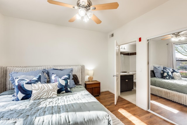 bedroom with ceiling fan, connected bathroom, and light hardwood / wood-style floors