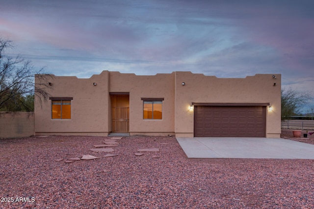 pueblo revival-style home with a garage