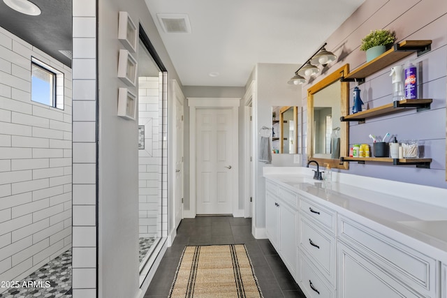 bathroom featuring tiled shower and vanity