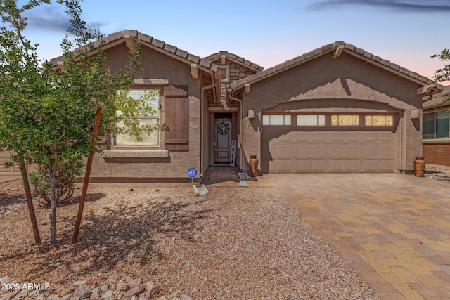 chalet / cabin with an attached garage, driveway, and a tile roof