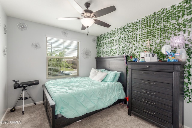 bedroom featuring light colored carpet, baseboards, and ceiling fan