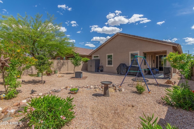 rear view of house with a fenced backyard, a patio area, and stucco siding