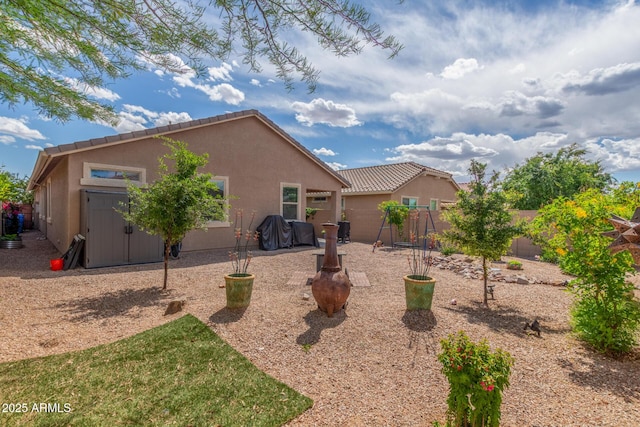 rear view of house with a fenced backyard and stucco siding