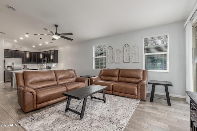 living area with visible vents, baseboards, recessed lighting, a ceiling fan, and light wood-style flooring