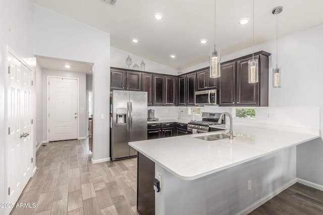 kitchen with dark brown cabinets, a sink, light countertops, lofted ceiling, and stainless steel appliances