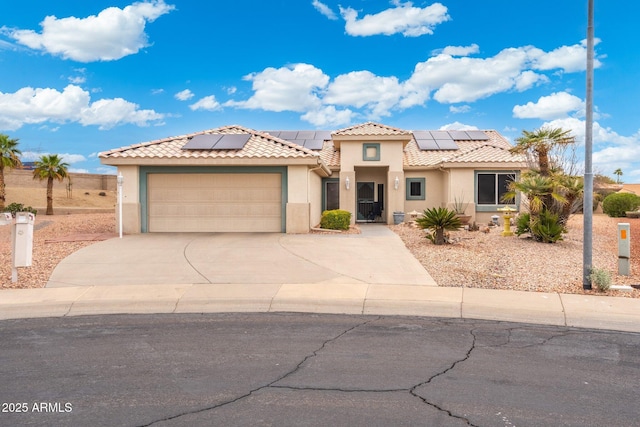 mediterranean / spanish-style home featuring an attached garage, driveway, a tile roof, and stucco siding