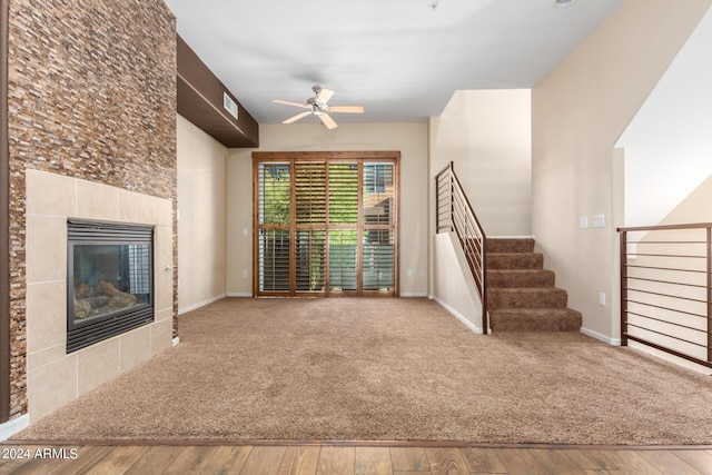 unfurnished living room featuring ceiling fan, visible vents, a fireplace, and wood finished floors