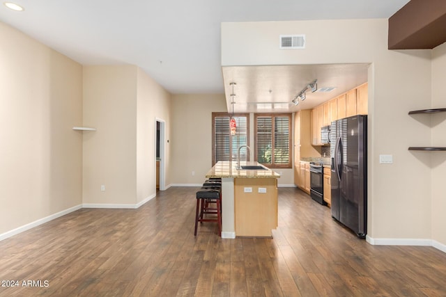 kitchen with electric stove, a center island with sink, stainless steel fridge with ice dispenser, visible vents, and a kitchen breakfast bar