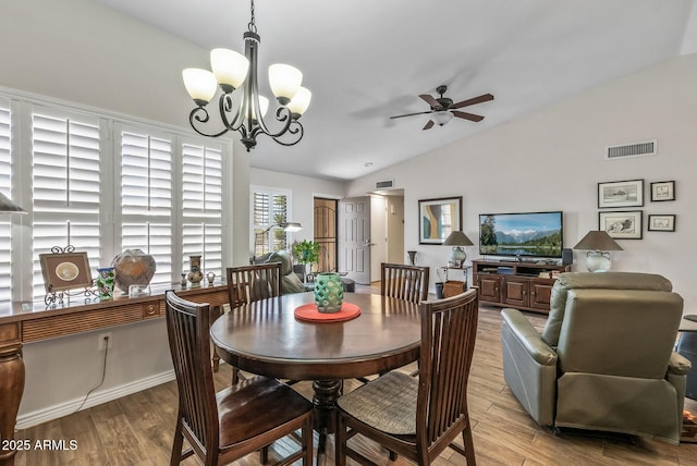 dining room with lofted ceiling, light wood-style floors, visible vents, and ceiling fan with notable chandelier