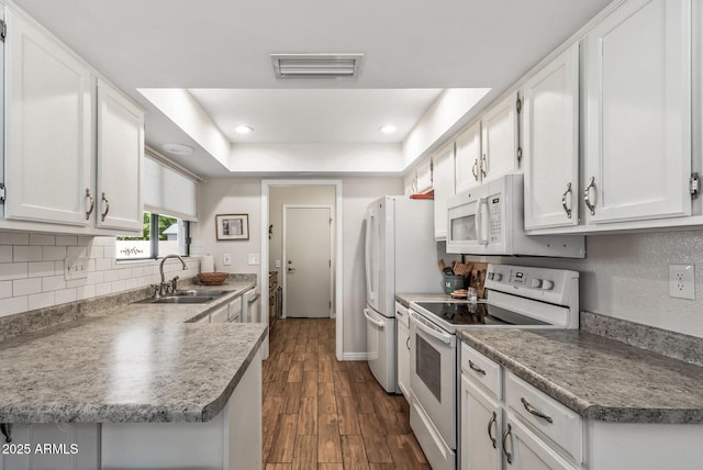 kitchen featuring a sink, white appliances, white cabinets, dark wood-style flooring, and visible vents