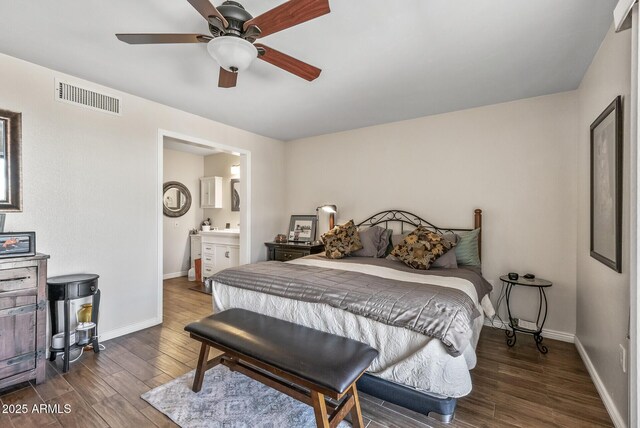 bedroom featuring wood finished floors, visible vents, baseboards, ceiling fan, and ensuite bathroom