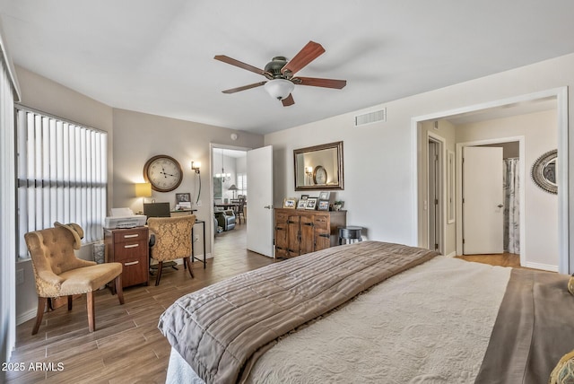 bedroom featuring wood finished floors, visible vents, baseboards, and ceiling fan