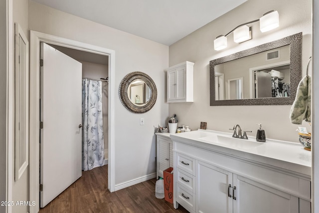 full bathroom featuring wood finished floors, vanity, curtained shower, baseboards, and visible vents