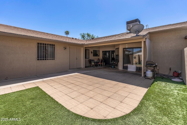 rear view of house with stucco siding and a patio area