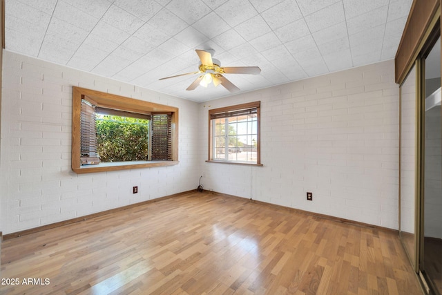 6217 W Orange Dr, Glendale, AZ 85301 - unfurnished room featuring wood finished floors, a ceiling fan, and brick wall
