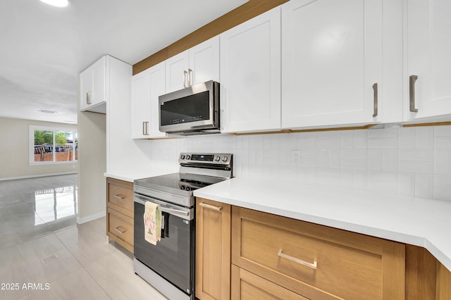8146 N 17th Dr, Phoenix, AZ 85021 - kitchen featuring appliances with stainless steel finishes, light countertops, backsplash, light tile patterned floors, and baseboards