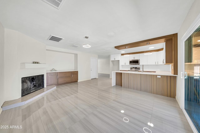 8146 N 17th Dr, Phoenix, AZ 85021 - unfurnished living room featuring a fireplace with raised hearth, light tile patterned floors, and a sink