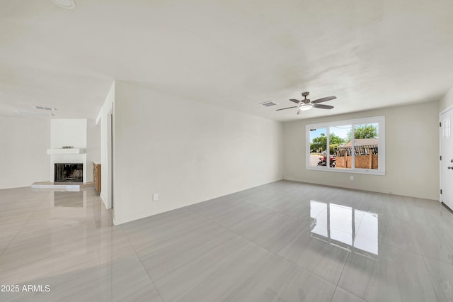 8146 N 17th Dr, Phoenix, AZ 85021 - unfurnished room featuring light tile patterned floors, ceiling fan, and a fireplace with raised hearth