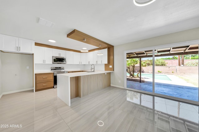 8146 N 17th Dr, Phoenix, AZ 85021 - kitchen featuring stainless steel appliances, a sink, baseboards, and light tile patterned floors