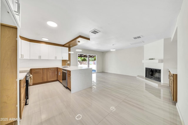 8146 N 17th Dr, Phoenix, AZ 85021 - kitchen with open floor plan, a sink, a peninsula, a fireplace with raised hearth, and light countertops