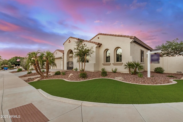 4453 S Huachuca Way, Chandler, AZ 85249 - mediterranean / spanish house with an attached garage, stucco siding, a front lawn, and a tile roof