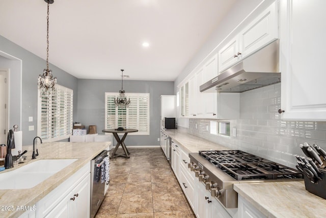 4453 S Huachuca Way, Chandler, AZ 85249 - kitchen with appliances with stainless steel finishes, a chandelier, under cabinet range hood, decorative backsplash, and white cabinets