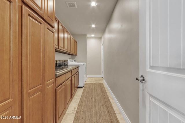 laundry area featuring washing machine and clothes dryer, sink, and cabinets