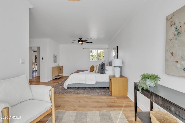 bedroom with light hardwood / wood-style flooring, ceiling fan, and ornamental molding