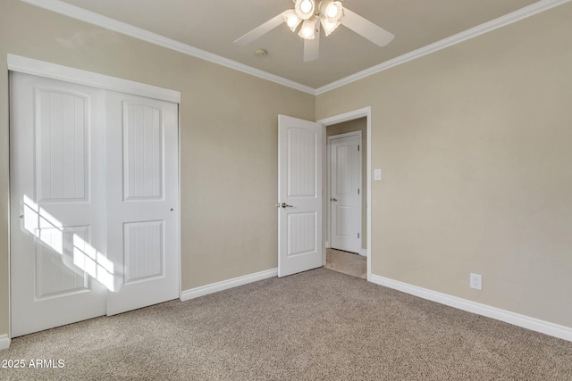 unfurnished bedroom featuring carpet flooring, ceiling fan, crown molding, and a closet