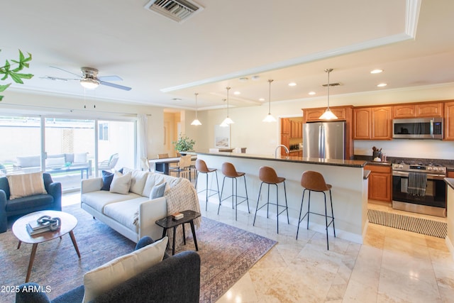 living room with ceiling fan, crown molding, and sink