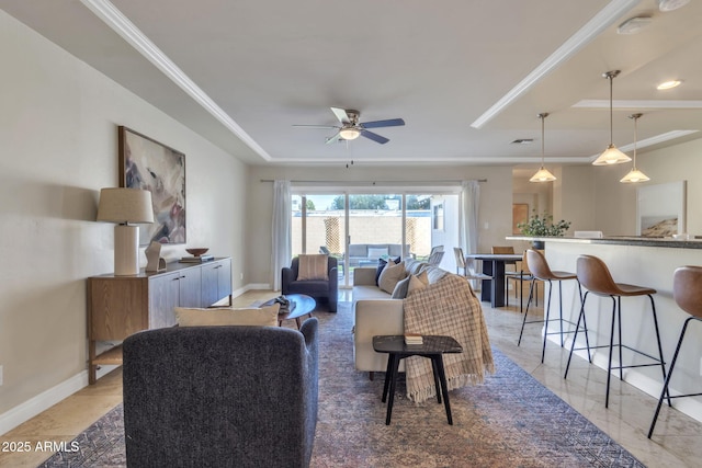 living room featuring ceiling fan, a raised ceiling, and crown molding