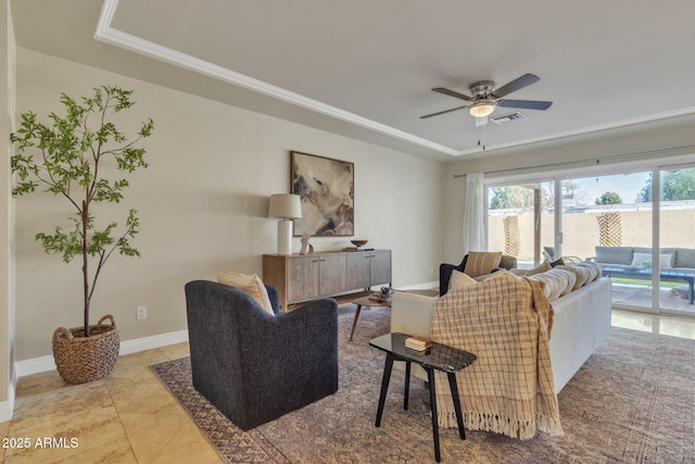 living room featuring a raised ceiling, ceiling fan, and light tile patterned flooring