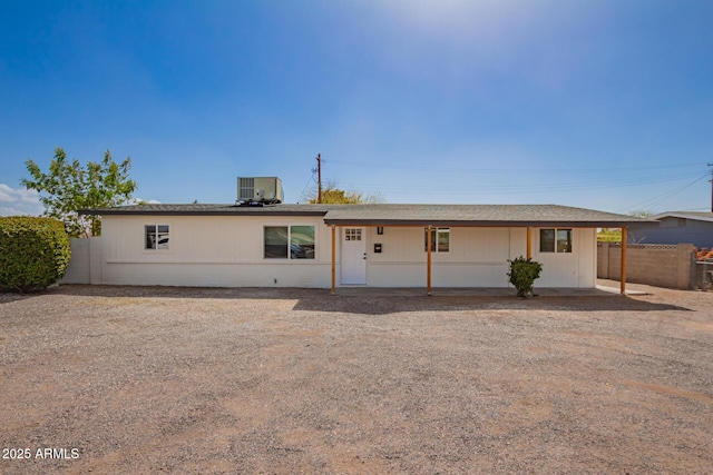 ranch-style house featuring fence and central AC