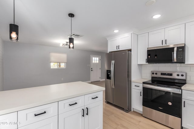 kitchen with visible vents, tasteful backsplash, appliances with stainless steel finishes, light countertops, and hanging light fixtures