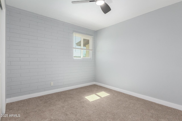 carpeted empty room with a ceiling fan and baseboards