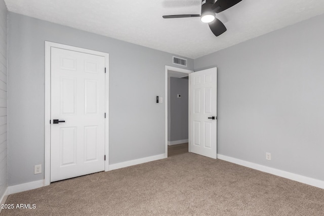 unfurnished bedroom featuring a ceiling fan, carpet flooring, baseboards, and visible vents
