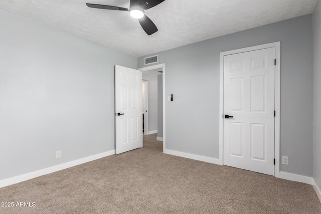 unfurnished bedroom featuring baseboards, visible vents, and carpet floors