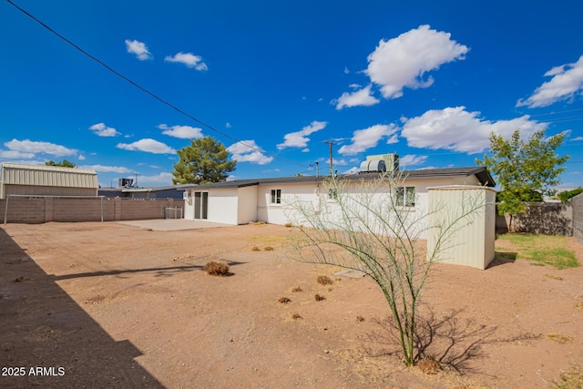 rear view of house with a fenced backyard, stucco siding, and a patio