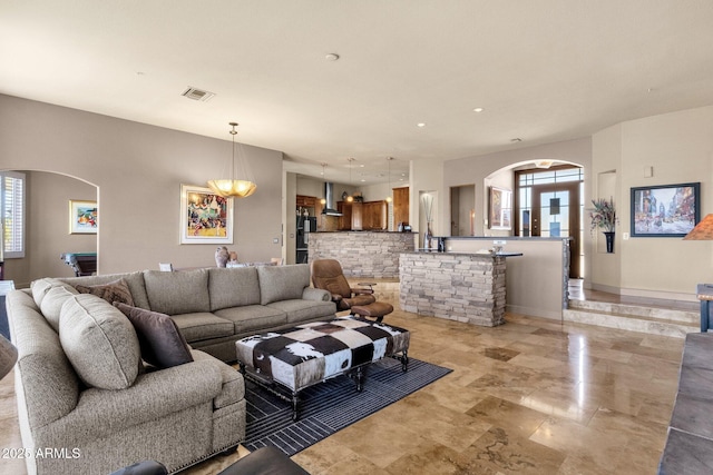 living area with recessed lighting, arched walkways, and visible vents