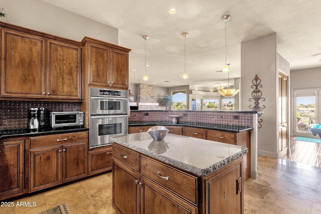 kitchen featuring tasteful backsplash, a center island, a peninsula, a toaster, and double oven