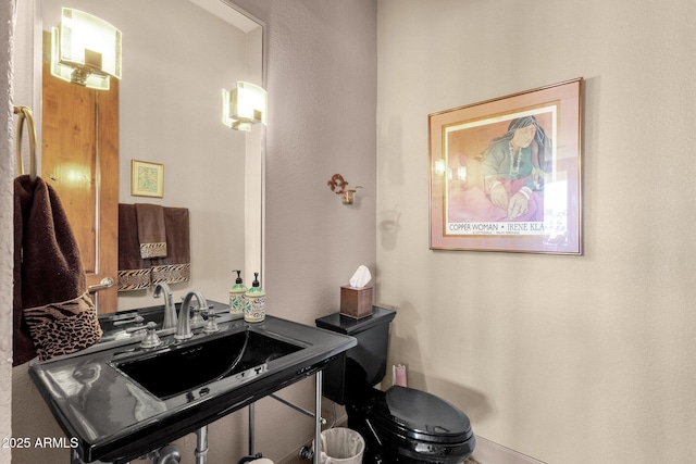 half bath featuring toilet and a sink