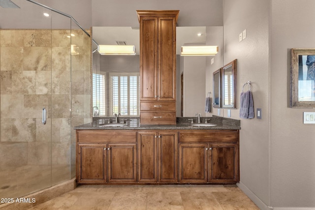 full bathroom featuring visible vents, a shower stall, double vanity, and a sink