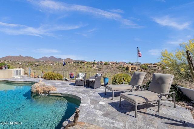 view of swimming pool featuring a patio, a mountain view, fence, and a fenced in pool