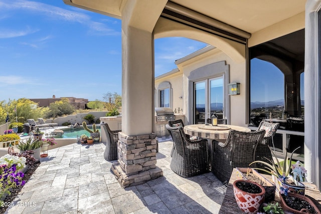 view of patio featuring a fenced in pool, outdoor dining space, a grill, and an outdoor kitchen