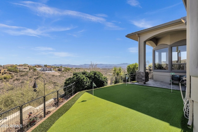 view of yard with a patio, a mountain view, and fence