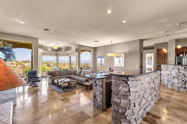 living room with a textured ceiling, visible vents, and recessed lighting