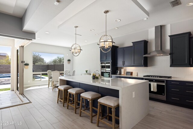 22421 N 34th St, Phoenix, AZ 85050 - kitchen with a kitchen breakfast bar, a chandelier, decorative backsplash, visible vents, and wall chimney exhaust hood