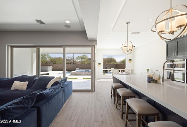 22421 N 34th St, Phoenix, AZ 85050 - living area featuring a healthy amount of sunlight, visible vents, an inviting chandelier, and light wood-style floors