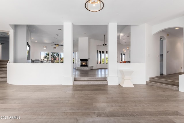 unfurnished living room with light wood-type flooring and ceiling fan